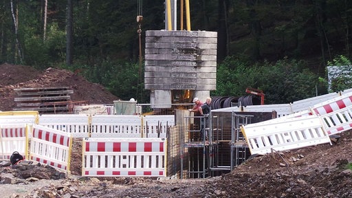 Zwei Arbeiter am Fuß eines Baukrans