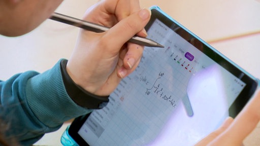 Ein Schüler mit einem Tablet in der Hand