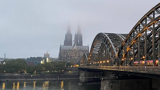 Der Kölner Dom liegt an einem Herbstmorgen im Nebel.