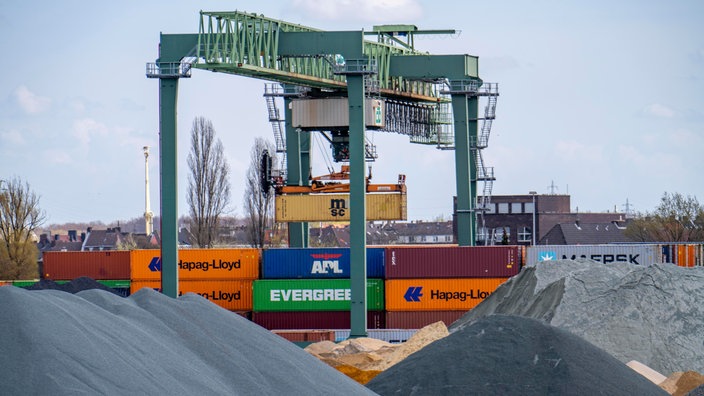 Ein Güterkran stapelt im Dortmunder Hafen Schiffscontainer übereinander