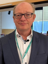 Alexander Montebaur steht vor einem Hörsaal.