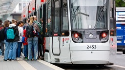 Menschen steigen an der Haltestelle Bertha-von Suttner-Platz in die Straßenbahn der SWB.