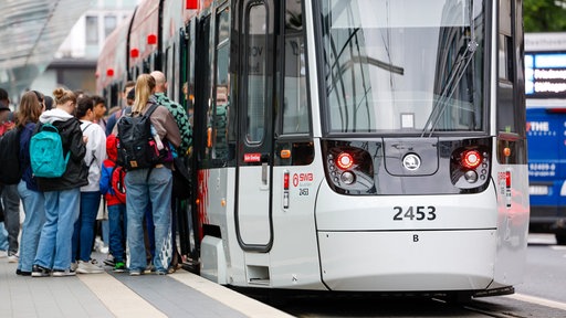 Menschen steigen an der Haltestelle Bertha-von Suttner-Platz in die Straßenbahn der SWB.