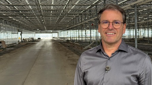 Christian Westhoff steht in einem alten Gewächshaus.