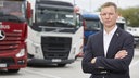 BGL Vorstandssprecher Dirk Engelhardt steht mit verschränkten Armen auf einem Parkplatz. Im Hintergrund sind unscharf LKW zu sehen.