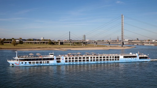 Ein Kreuzfahrtschiff auf dem Rhein bei Düsseldorf, im Hintergrund die Rheinkniebrücke