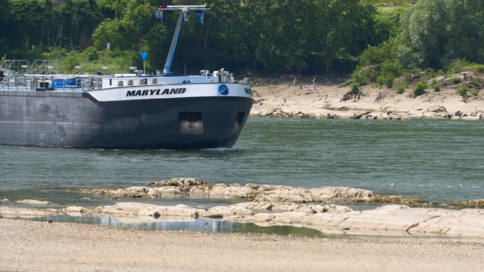 Ein Frachtschiff passiert bei Niedrigwasser eine Untiefe im Rhein
