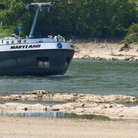 Ein Frachtschiff passiert bei Niedrigwasser eine Untiefe im Rhein