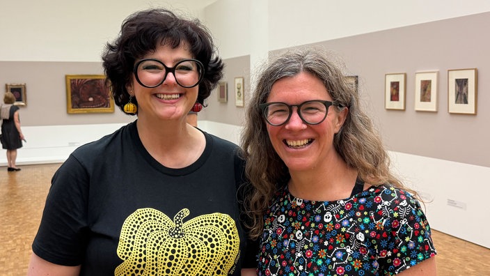 Zwei Frauen stehen in der Ausstellung.