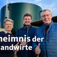 Zwei Männer und eine Frau stehen lächelnd und mit nach oben ausgestreckten Daumen vor einem Speicherkraftwerk. Darunter der Titel: ,,Das Geheimnis der Energielandwirte"