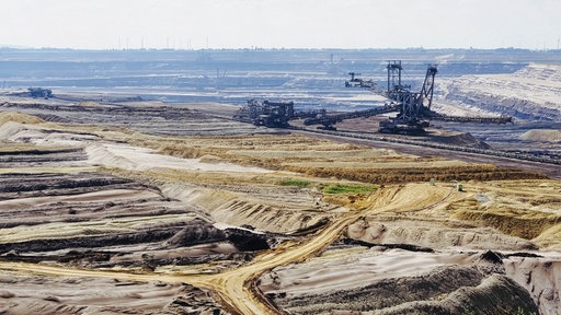 Ausblick über den Braunkohle Tagebau Garzweiler mit großem Bagger.