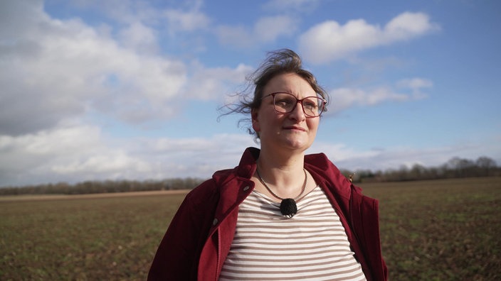 Betriebsleiterin Anne Korte steht auf einem Feld auf ihrem Hof in Petershagen