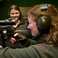 Eine Frau schießt mit einem Jagdgewehr auf einem Schießstand.