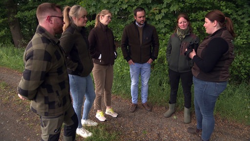 Die angehenden Jägerinnen und Jäger besprechen sich im Wald. 