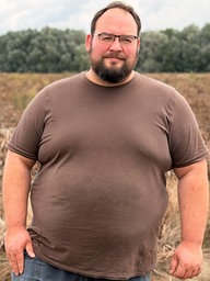 Landwirt Julian Freisendorf steht vor einem seiner Felder und schaut in die Kamera.