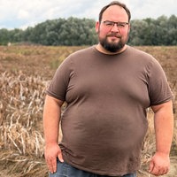Landwirt Julian Freisendorf steht vor einem seiner Felder und schaut in die Kamera.