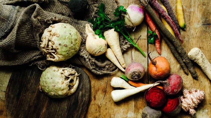Wintergemüse liegt auf einem Holztisch, unter anderem Möhren und Rote Beete