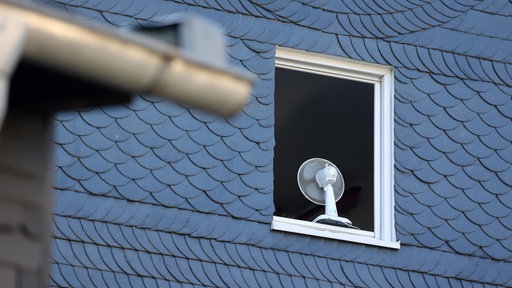 Ein Fenster in einem Haus am Morgen komplett zum lüften geöffnet. In dem Fenster steht ein Ventilator.