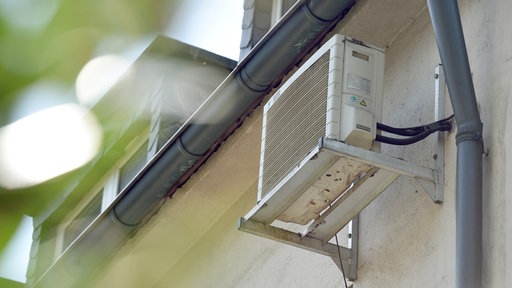 Eine Klimanlage hängt an der Seite eines Hauses