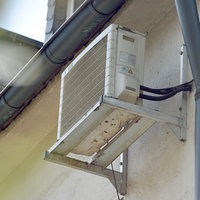 Eine Klimanlage hängt an der Seite eines Hauses