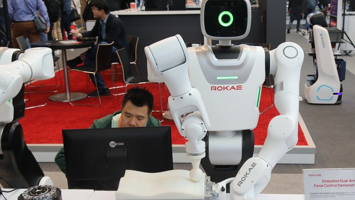 Humanoider Roboter arbeit mit einm menschlichen Kollegen Schulter an Schulter