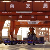 Unbemannte Fahrzeuge fahren unter Containerbrücken am Containerterminal des Hafens bei Tangshan in der nordchinesischen Provinz Hebei. 