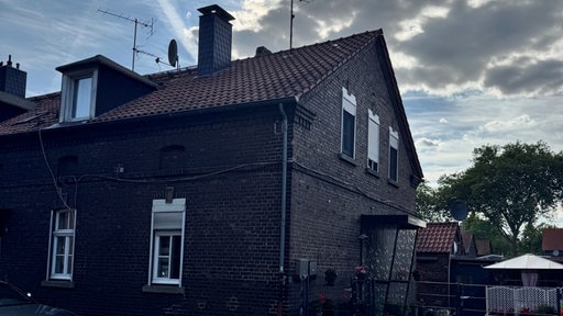 Ein Zechenhaus. Im Hintergrund ein blauer Himmel und ein paar Wolken. 