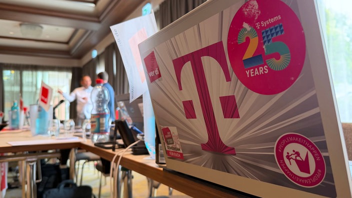 Laptop mit Telekom-Logo in Konferenzraum