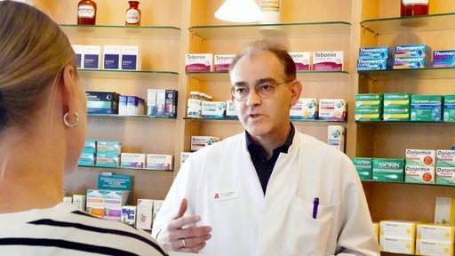Apotheker Dr. Oliver Röttger im Gespräch mit einer Kundin.