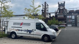 Ein weißer Lieferwagen mit der Aufschrift "Kuepper Solutions", darunter ein gerät, das eine Art Flamme speit.