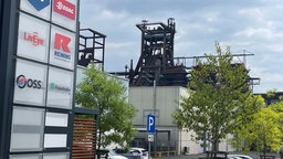 Industriebauten auf Phoenix West, davor ein Schild mit den Logos verschiedener Unternehmen, Kueppers Solutions oder Honeywell sind nicht dabei.