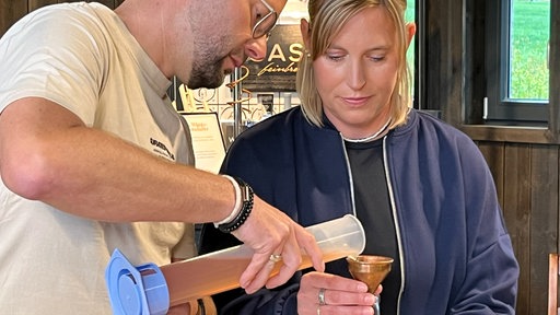 Teilnehmer des Workshops füllen ihre alkoholfreien Drinks ab