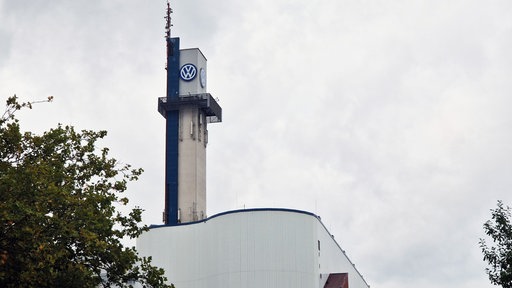 Ein Turm des VW-Werks in Osnabrück vor einem bewölkten Himmel.