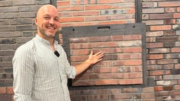 Marcus Gillrath, Chef der Ziegelwerke, steht vor einer Wand mit dem Recycling-Ziegel Circobrick 